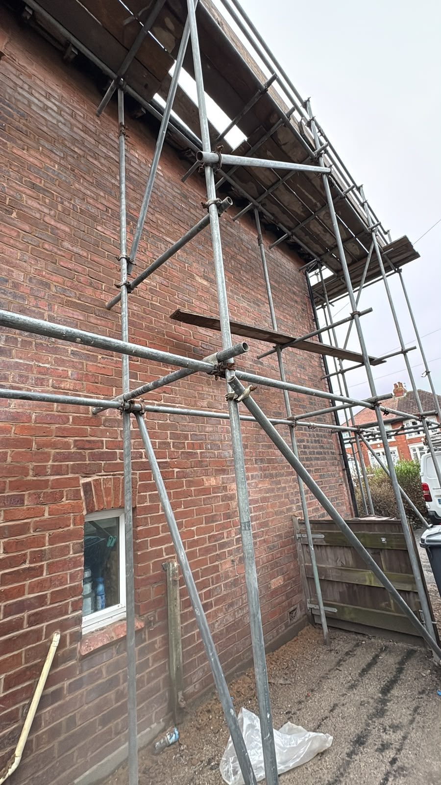 Scaffolding erected around a brick house in Lancashire ahead of roof and property maintenance works
