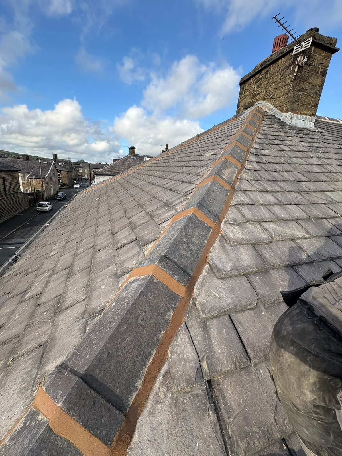 Newly repointed hip line running down a stone slate roof in East Lancashire