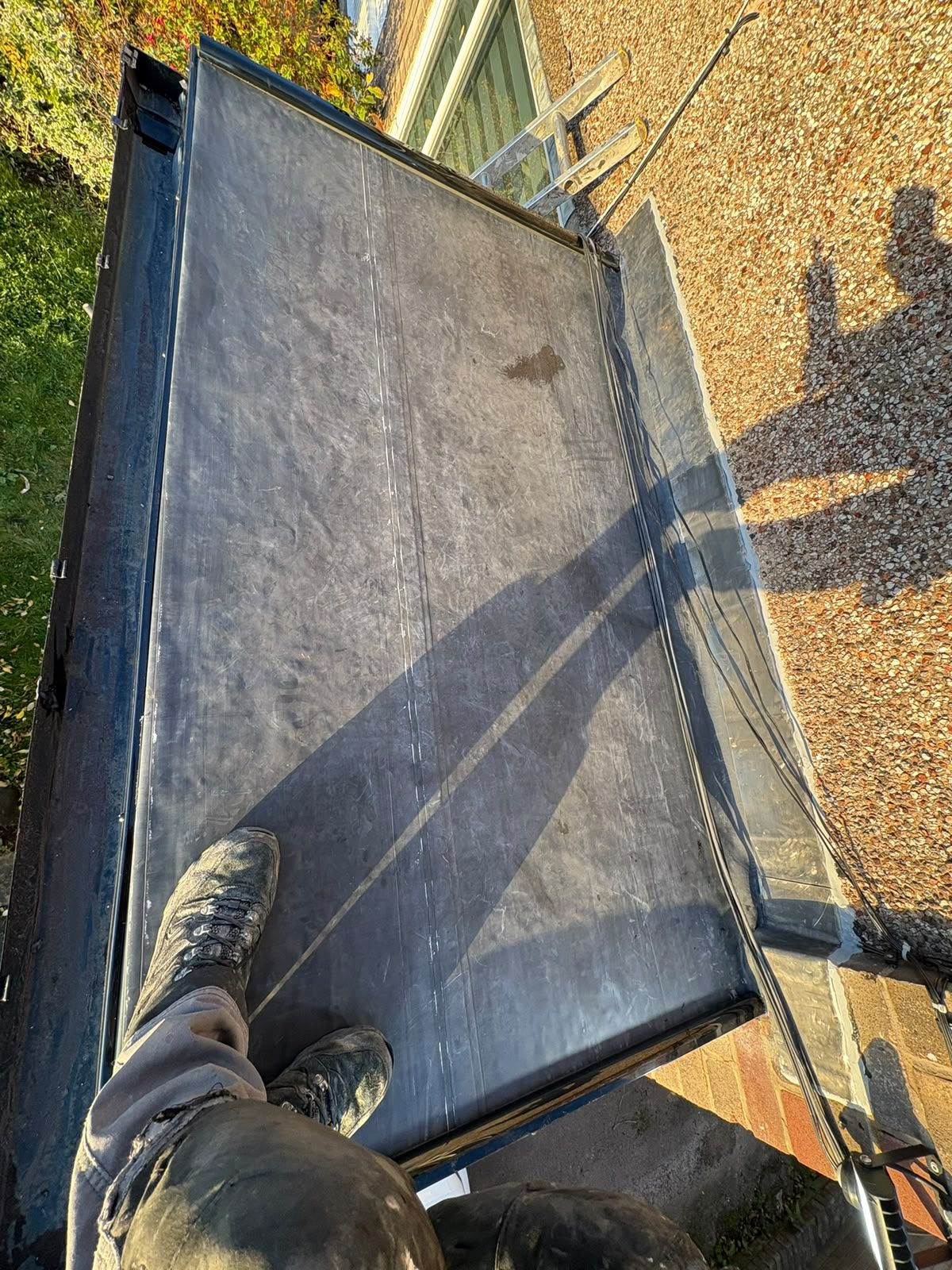 Newly installed grey single-ply flat roof membrane laid over a rear extension in Lancashire