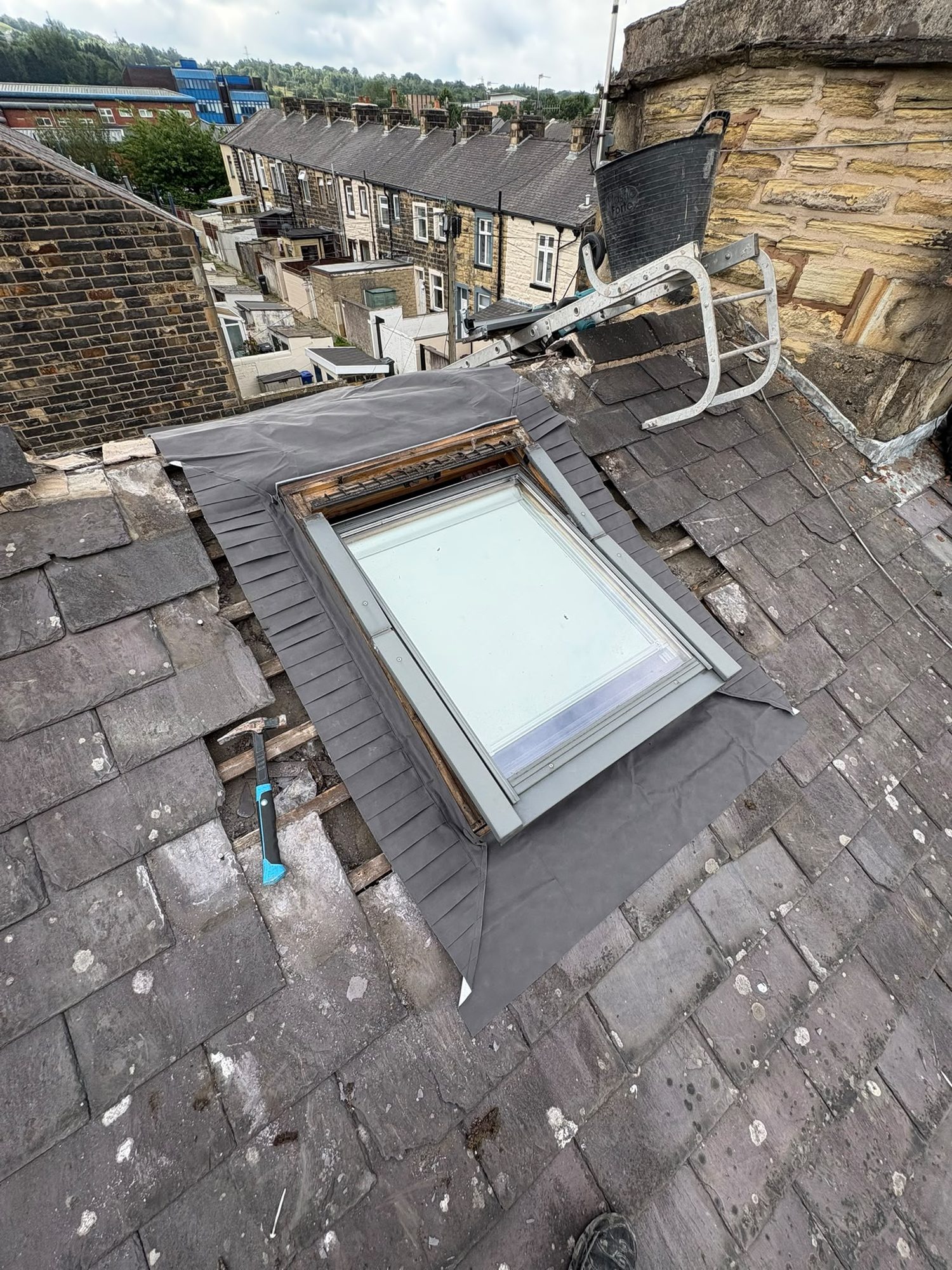 Roof window installation in progress with underlay and flashing being detailed around the opening