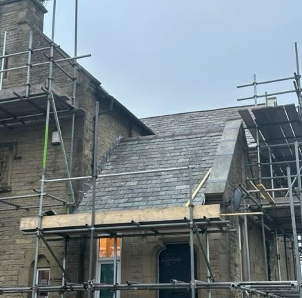 Stone property under scaffold with the slate roof and ridge being renewed